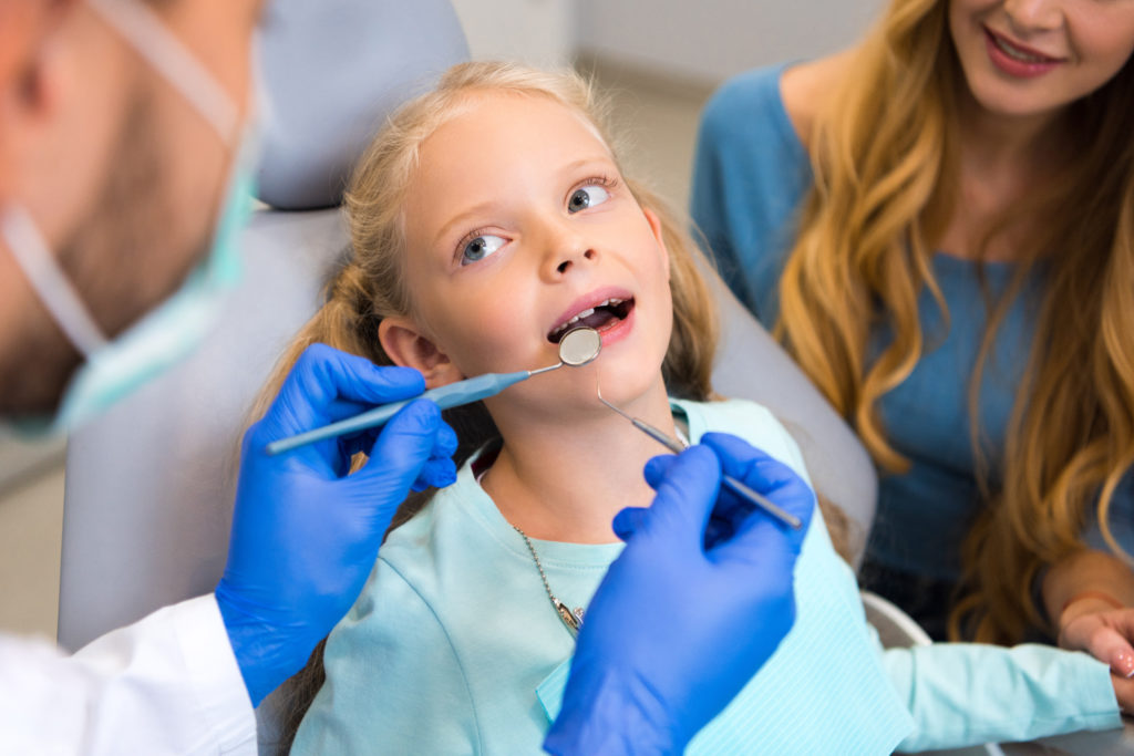 When Should Kids Start Seeing A Dentist? Gunnell Family Dentistry little girl getting her teeth checked Logan Utah